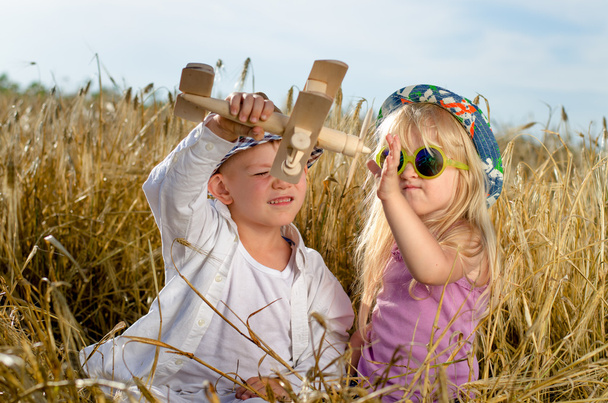 twee jonge kinderen spelen met een model vliegtuig - Foto, afbeelding