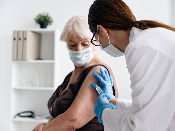 Nurse giving an injection to an elderly woman patient vaccine passport epidemic covid-19 - Foto, imagen