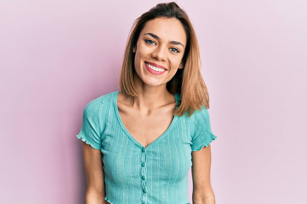 Joven mujer rubia caucásica que usa una camiseta azul casual con una sonrisa alegre y fresca en la cara. persona afortunada.  - Foto, Imagen