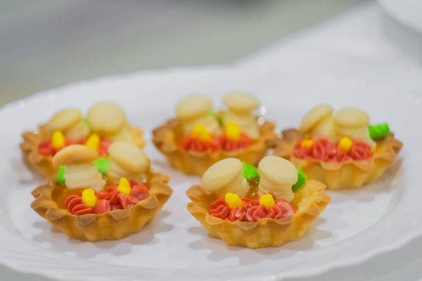 Frische Mürbeteigkuchen mit Sahne und süßen Pilzen zum Verkauf - Foto, Bild