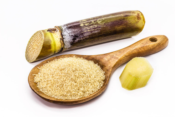wooden spoon with raw sugar, demerara sugar, with sugar cane, isolated white background with copyspace - Photo, Image