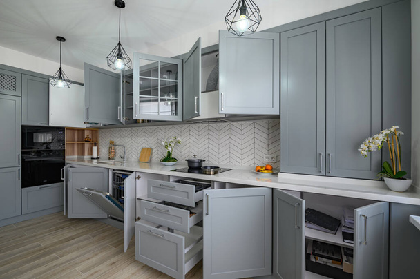 Moderní šedobílý moderní kuchyňský nábytek s otevřenými dveřmi - Fotografie, Obrázek