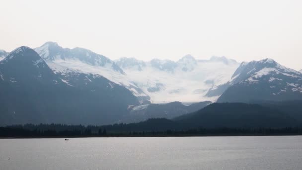 Werkboot zeilen op het meer. Het ochtendzonlicht bracht de oppervlakte van het meer in kaart. De fjorden van Alaska, unieke natuurlandschappen. Alaska, USA. juni 2019. - Video