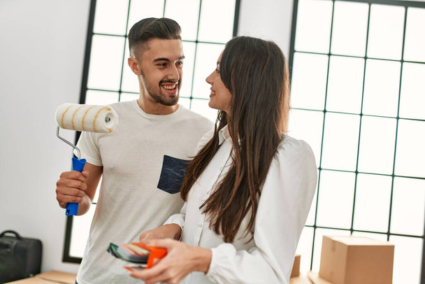 Genç İspanyol çift yeni evlerinde boya silindiri kullanıyorlar.. - Fotoğraf, Görsel
