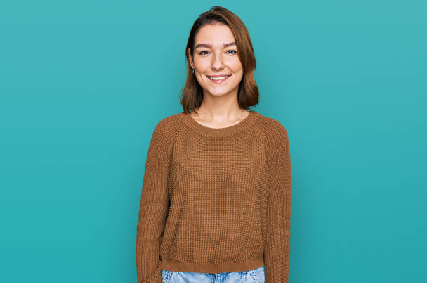 jong Kaukasisch meisje dragen casual kleding kijken positief en gelukkig staan en glimlachen met een zelfverzekerde glimlach tonen tanden  - Foto, afbeelding