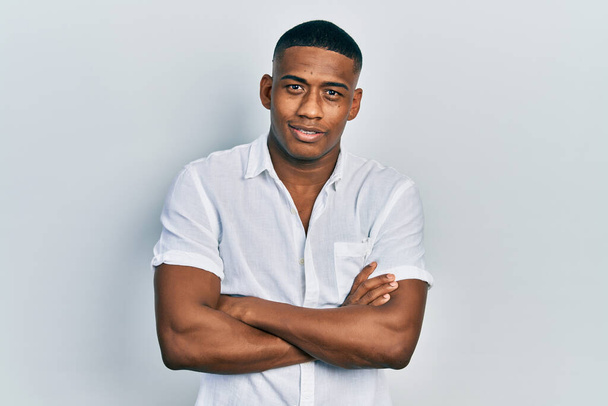 Young black man wearing casual white shirt happy face smiling with crossed arms looking at the camera. positive person.  - Photo, Image