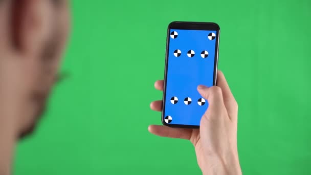 Смартфон з точками стеження на зеленому екрані в руках людини, який торкається ліворуч і натискає на дисплей
 - Кадри, відео