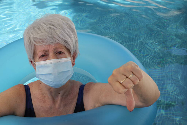 πορτρέτο της ώριμης γυναίκας με μαγιό και μάσκα αναπνοής στην πισίνα την ηλιόλουστη καλοκαιρινή μέρα - Φωτογραφία, εικόνα