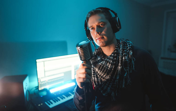 Hombre guapo grabando una canción en un estudio de grabación. - Foto, imagen