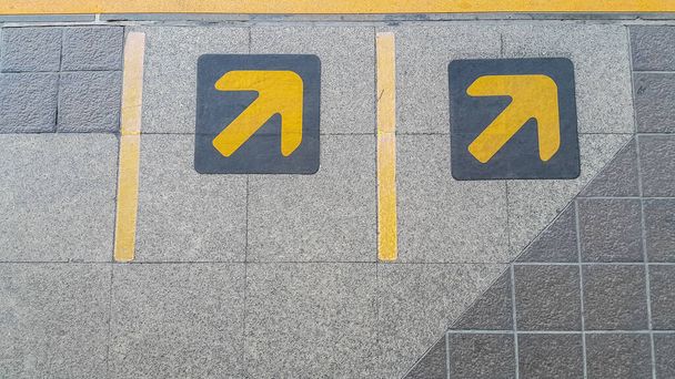 šipka znamení v žluté barvě malované na černou na čekací zóně pro vlak, metro - Fotografie, Obrázek