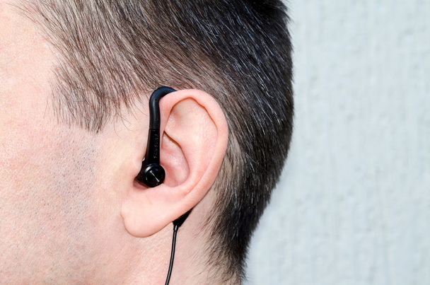 навушники в вухо чоловіка
 - Фото, зображення