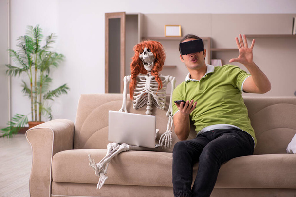 Junger Mann mit weiblichem Skelett in Virtual-Reality-Konzept - Foto, Bild