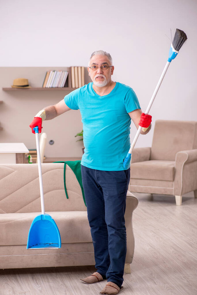 Öreg ember takarítja a házat. - Fotó, kép