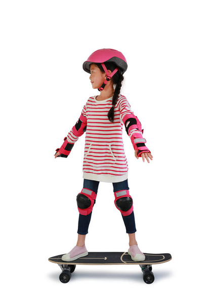 Asian little girl child skating on skateboard isolated over white background. Kid riding on skateboard. Image with Clipping path - Foto, afbeelding