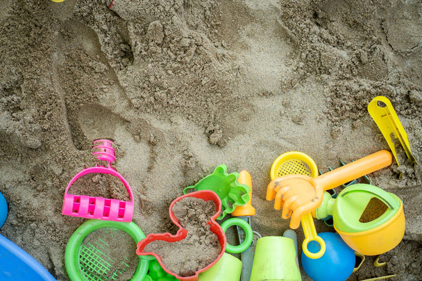 Un grupo de coloridos juguetes de plástico en la arena - Foto, Imagen