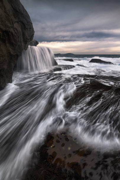 una cascata in un specchio d'acqua sulla costa - Foto, immagini