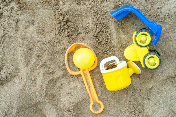 Un primer plano de juguetes de colores en la arena en la playa - Foto, Imagen