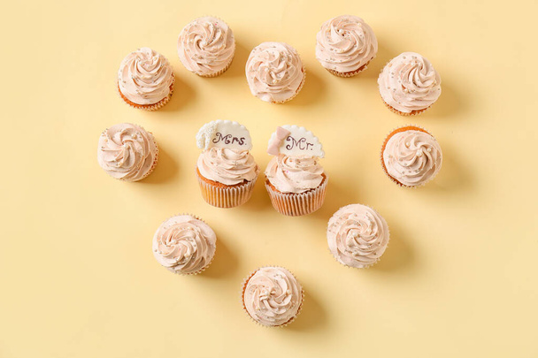 Tasty wedding cupcakes on color background - Foto, Imagen