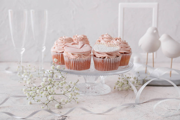 Postre soporte con sabrosos cupcakes de boda en la mesa - Foto, Imagen