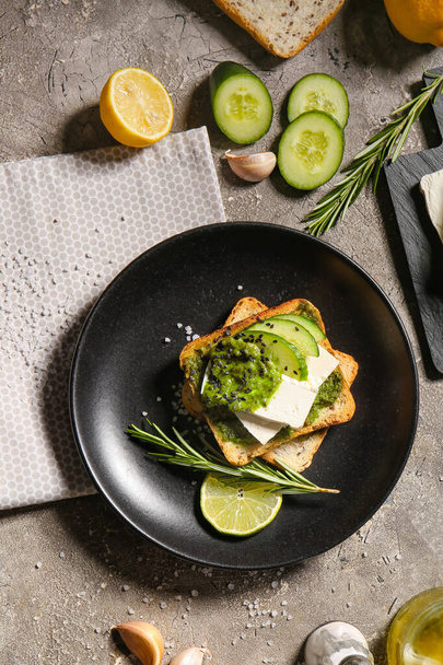 Toast savoureux avec sauce pesto et citron vert sur fond grunge - Photo, image