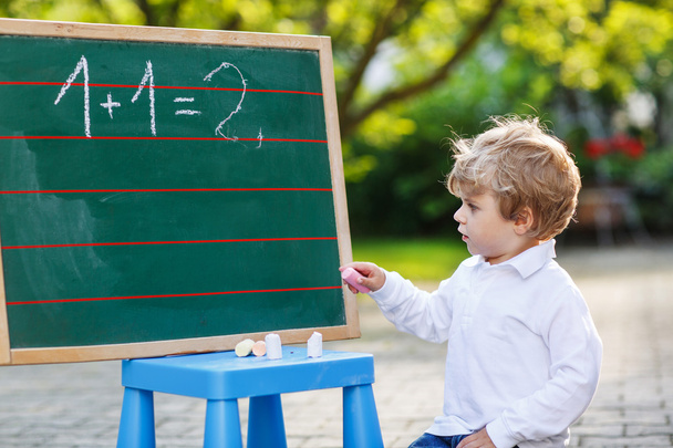 Little boy at blackboard practicing mathematics - Photo, Image