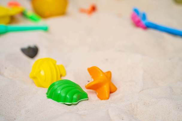 A closeup shot of colorful toys on the sand at the beach - Foto, Imagen
