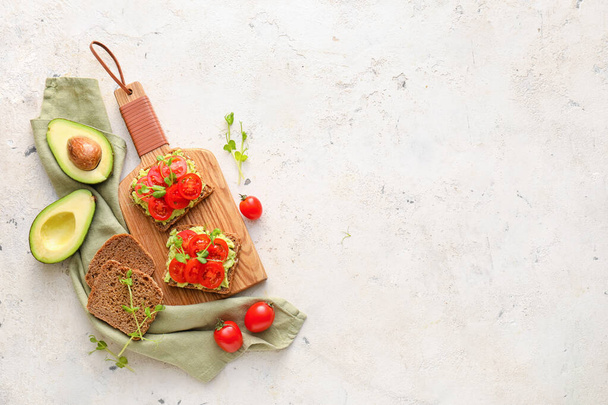 Leckere Bruschettas mit Tomate und Guacamole auf hellem Hintergrund - Foto, Bild