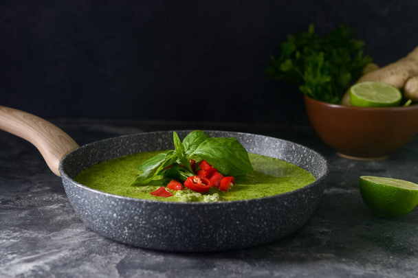 Frying pan with tasty green chicken curry on grunge background - Photo, Image