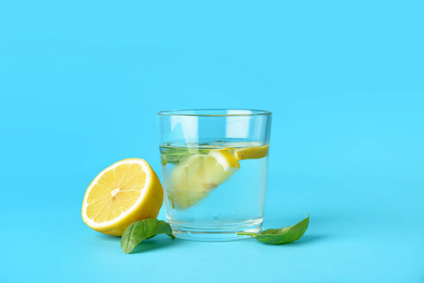 Glass of tasty lemonade with basil on color background - Photo, image