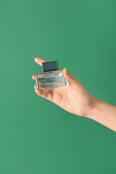 Female hand with perfume on color background - Zdjęcie, obraz