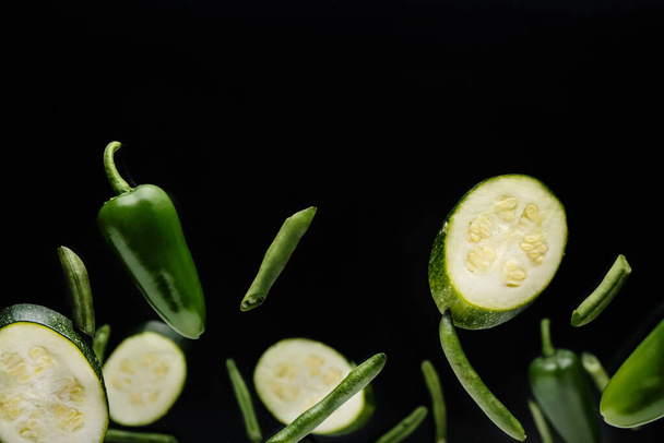 Flying green vegetables on dark background - Foto, immagini