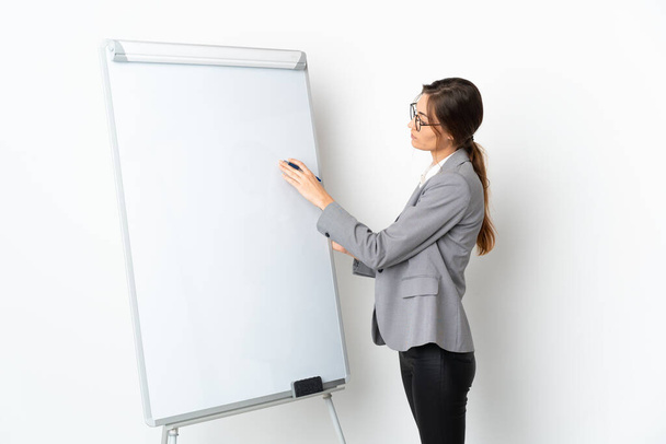 Young Ireland woman isolated on white background giving a presentation on white board - Фото, зображення