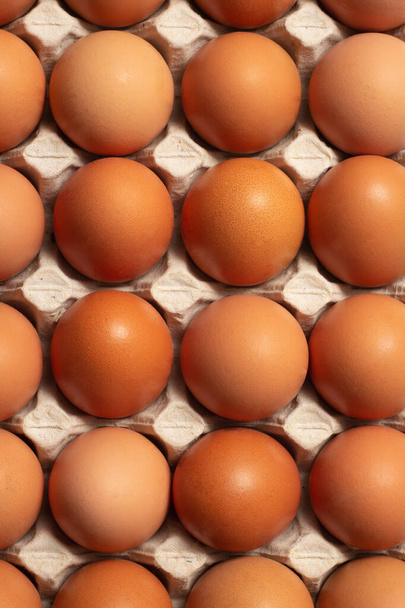 Huevos crudos frescos de pollo en un envase de cartón. Ingredientes para cocinar. Concepto para una alimentación saludable. Enfoque selectivo. - Foto, imagen