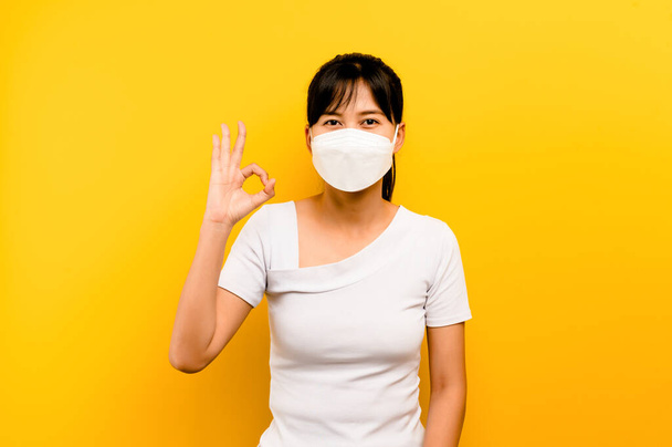 Mujer asiática que muestra usar máscara antivirus para proteger a otros de contraer el coronavirus COVID-19, concepto de prevención del coronavirus. - Foto, imagen