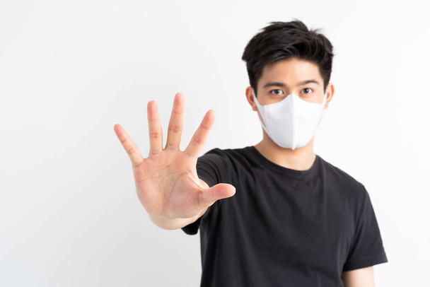 Medeni 19, Yüz Maskesi takan Asyalı adam Corona virüsü salgınını durdurmak için el hareketini durdurun, Covid-19 Coronavirus konseptini koruyun.  - Fotoğraf, Görsel