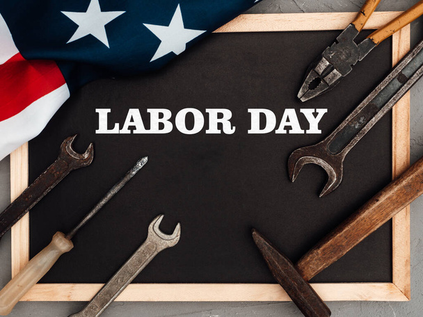 LABOR DAY. Hand tools and the Flag of the United States of America lying on the table. View from above, close-up. Congratulations to family, relatives, friends and colleagues. National holiday concept - Foto, immagini