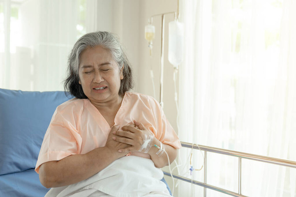 Senior mujer asiática que sufre de dolor en el pecho ataque al corazón en casa - enfermedad del corazón senior  - Foto, Imagen