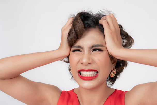 Ritratto e faccia ravvicinata di giovane donna asiatica usato le mani a testa grottesca sui capelli con i denti mordono a causa dello stress, copiare lo spazio su sfondo bianco - Foto, immagini