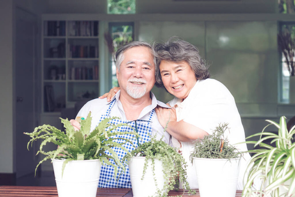 Asian senior couple smile watering plants take care of trees , happy couple gardening - lifestyle senior couple concept - Foto, imagen