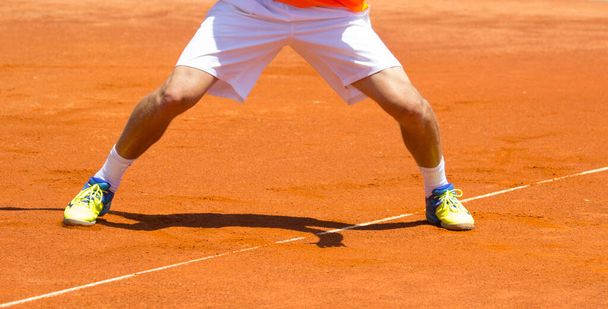 Athlete's feet in shorts on tennis court  - Photo, Image