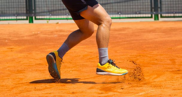 Voeten van de sporter in korte broek op de tennisbaan  - Foto, afbeelding