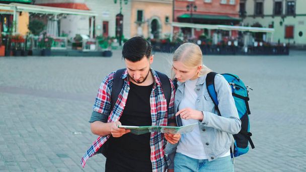 Jeune couple de touristes avec carte à la recherche d'un nouveau lieu historique dans le centre-ville - Photo, image