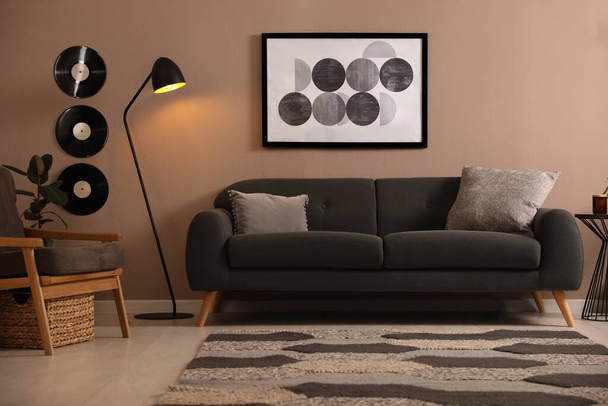 Stylish living room interior with comfortable dark sofa - Fotó, kép