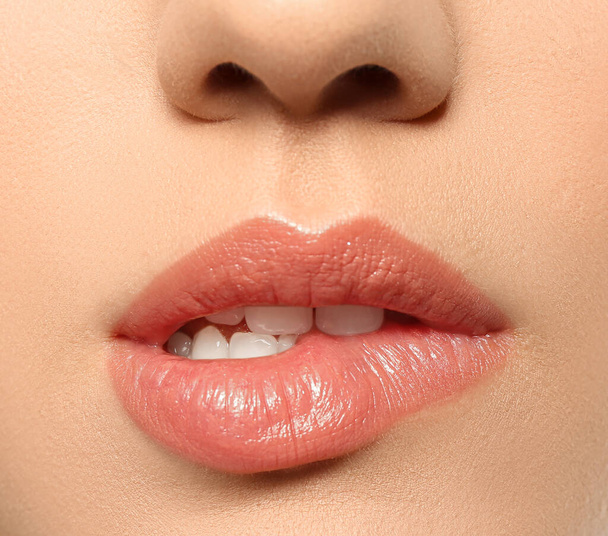 Beautiful young woman biting lip on grey background, closeup - Fotoğraf, Görsel