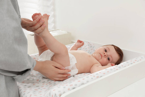 Mother changing baby's diaper on table at home, closeup - Photo, Image