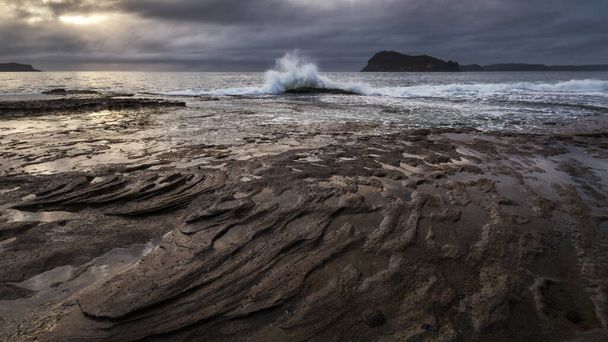 каменистый пляж рядом с океаном - Фото, изображение