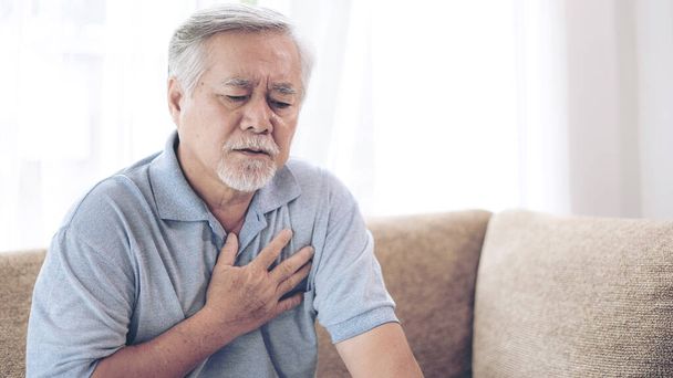 自宅で胸の心臓発作で痛みに苦しんでいるシニア男性アジア人-高齢者の心疾患  - 写真・画像