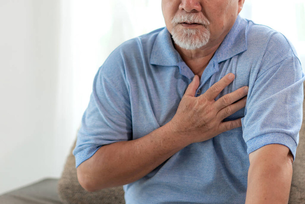 Старший азиат мужского пола страдает от сильной боли в груди сердечного приступа дома - пожилые люди сердечно-сосудистые заболевания - Фото, изображение