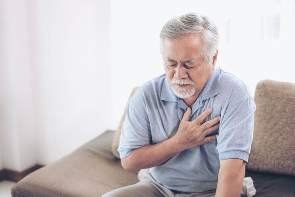 Hombre mayor asiático que sufre de dolor en el pecho ataque al corazón en casa - enfermedad cardíaca de alto nivel - Foto, imagen