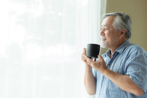 Idős férfi úgy érzi, boldog ivás kávé reggel, élvezi az időt az otthoni beltéri háttér - életmód senior boldogság koncepció - Fotó, kép